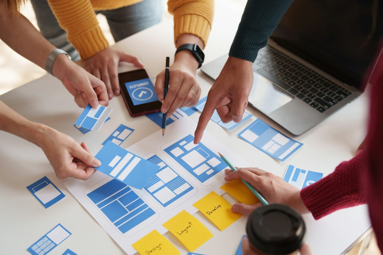 Group of ux developer and ui designer brainstorming about app interface design at modern office